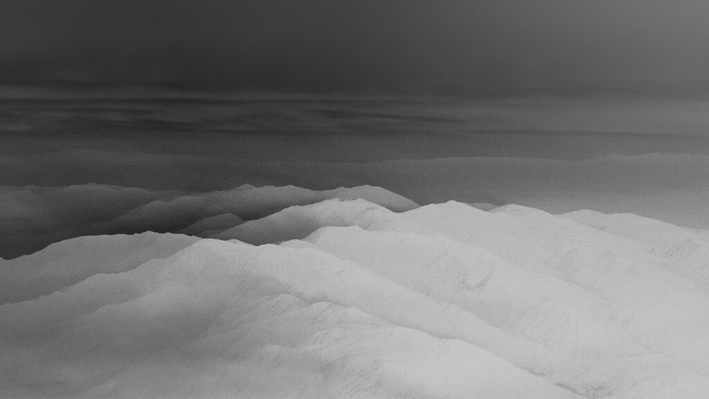 Dark misty mountains with cyberpunk atmosphere in grayscale